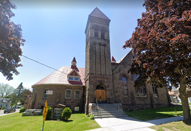 Richardsonian Romanesque style church, with stained glass windows, and bell tower.